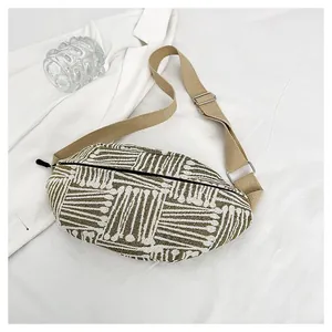 Macro shot of olive green geometric jacquard fabric and canvas strap on chest bag