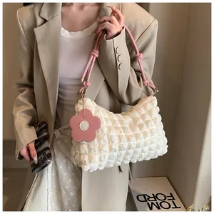 Detailed texture of white bubble fabric tote bag with pink straps and flower charm