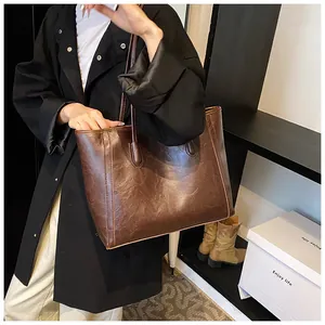 Brown vintage soft leather tote bag worn by model for office and daily lifestyle