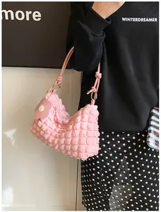 Detail of pink bubble texture shoulder bag with flower charm and zipper closure