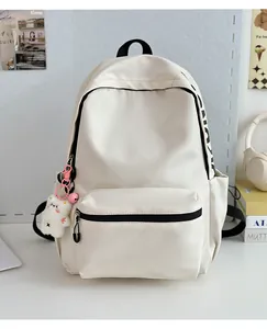 Detail van de crème nylon rugzak met zijprint en een schattige witte beer sleutelhanger