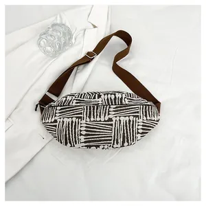 Detailed top view of a striped canvas waist bag with geometric patterns and brown strap