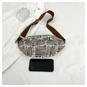 Detail showing capacity of striped canvas fanny pack compared with a smartphone