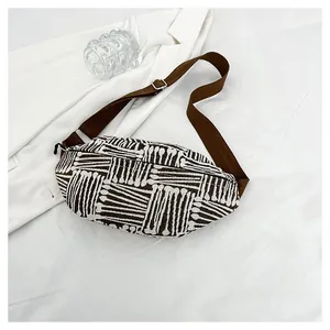Close-up of geometric striped canvas texture and adjustable strap on the crossbody chest bag