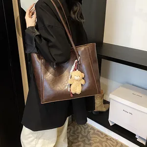 Retro brown soft leather tote bag with plush bear charm for daily office commute