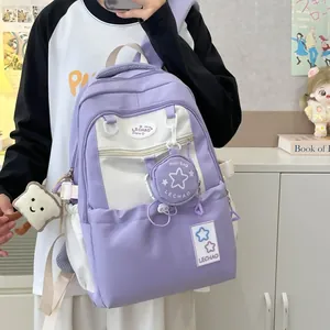 Detail des lila-weißen Studentenrucksacks mit Stern-Minitasche und Plüschanhänger