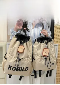 Size comparison of large and small beige drawstring backpacks with toast plush charms