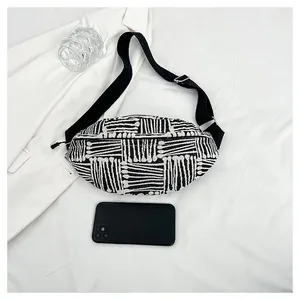 Detail view of ethnic style canvas chest bag with black and white woven stripe pattern