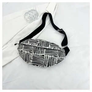 Detail of bohemian chest bag with black and white geometric woven pattern and strap