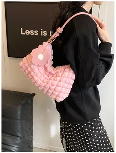 Detail of pink popcorn texture handbag with 3D flower charm and knotted shoulder strap