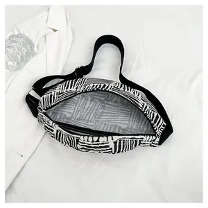 Detail of canvas chest bag with black and white stripes and adjustable nylon strap