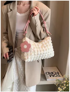 Close-up of white bubble texture tote with pink rope handle and flower charm detail
