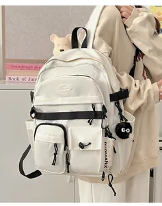 Detail view of cream-white backpack featuring multiple pockets and black contrast zippers