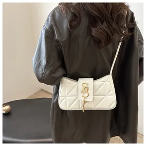 Close-up of white quilted leather underarm bag with gold SSS logo and tassel detail