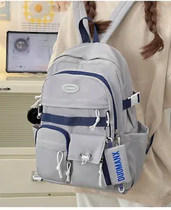 Detail of grey and navy campus backpack showing multiple functional pockets and side buckles