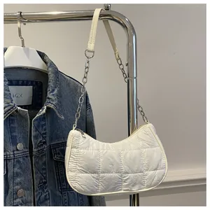 Detalle del bolso de media luna blanco acolchado con cadena de plata y cremallera