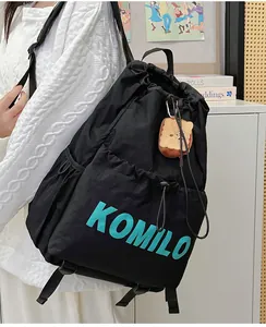 Detail of lightweight black drawstring backpack with cyan logo and plush toast charm