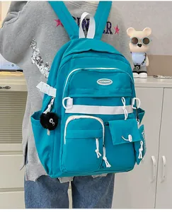 Detail view of teal nylon backpack with multi-pocket design and contrast webbing