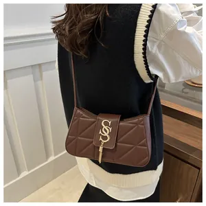 Close-up of brown quilted faux leather shoulder bag with gold SS buckle and metal tassels