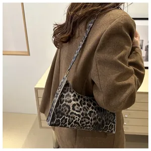 Fashionable leopard print crescent underarm bag shown styled with a brown blazer