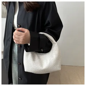 Detail of white woven hobo bag showing the intricate faux leather braided texture