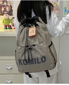 Outdoor lightweight grey drawstring backpack with Komilo text and plush charm detail
