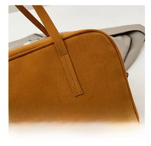 Close-up of tight stitching and premium matte texture on the brown shoulder handbag