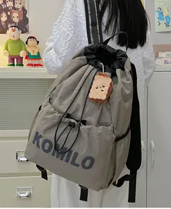 Detail of grey lightweight drawstring backpack with KOMILO logo and plush toast charm