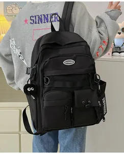 Detail view of black waterproof nylon backpack with functional straps and plush charm accessory