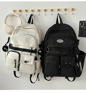 Detail of minimalist school backpacks with plush ball pendant and small side wallet