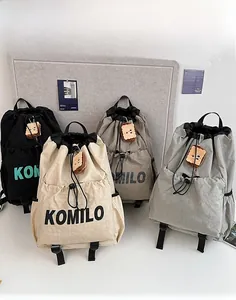 Detailed view of lightweight nylon drawstring backpacks in four colors with charms