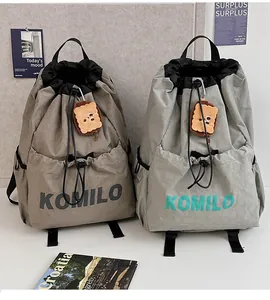 Detail of water-resistant nylon drawstring backpacks with cute plush cookie charms