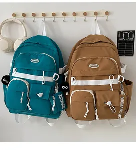 Detail of blue and brown multi-pocket nylon backpacks with plush charms and zip pouches