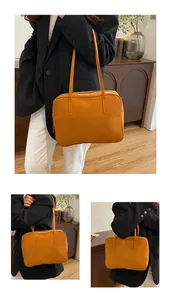 Detailed view of the ginger yellow frosted suede tote bag worn by a model in a room