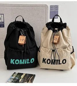 Detail of waterproof nylon drawstring backpacks in black and beige with logo branding