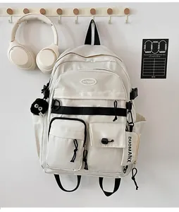Detail of cream white canvas backpack with multi-pocket design and black contrast straps