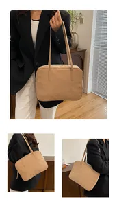 Detail view of khaki matte leather tote bag showing slim straps and zipper closure