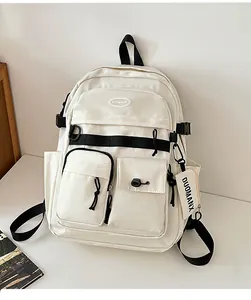 Detail of white utility backpack with multiple pockets and mini coin purse charm