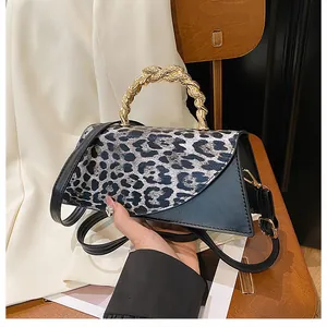 Detail of leopard print flap with golden twist handle and asymmetric PU leather design