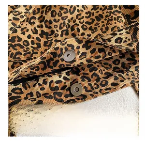 Close-up of metal magnetic snap closure on leopard print canvas tote bag with texture