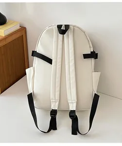 Rear view detail of the minimalist beige canvas backpack with black straps and side pocket