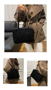 Detail of minimalist matte black shoulder bag with slim straps and silver zipper closure