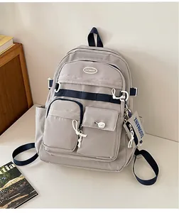 Close-up of a multi-pocket cargo style backpack with a detachable navy blue mini pouch