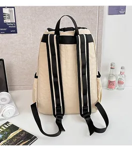Detailed back view of lightweight beige nylon backpack with wide adjustable black straps