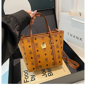 Detailed close-up of brown monogram bucket bag with gold hardware on gift box