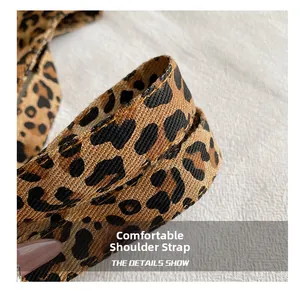 Detailed view of leopard print canvas strap with reinforced stitching on the tote bag