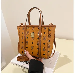 Detailed view of brown bucket bag featuring cartoon bear patterns and leather texture