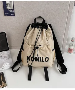 Close-up of lightweight drawstring backpack with front zip pocket and KOMILO logo