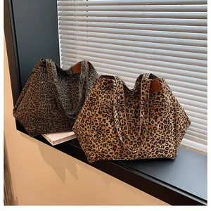 Close-up of leopard print tote bags with canvas texture and metal rivet detail