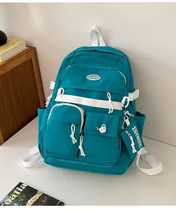 Detail of teal multifunctional backpack with white contrast straps and mini pouch
